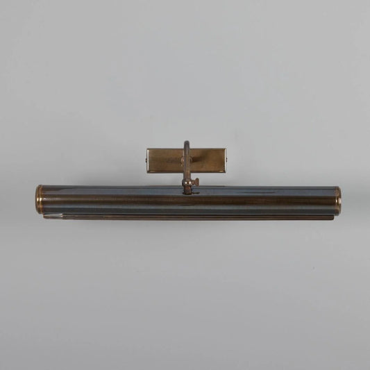 Decorative wall sconce with a metallic finish on a gray background